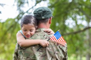 American soldier in uniform holding daughter